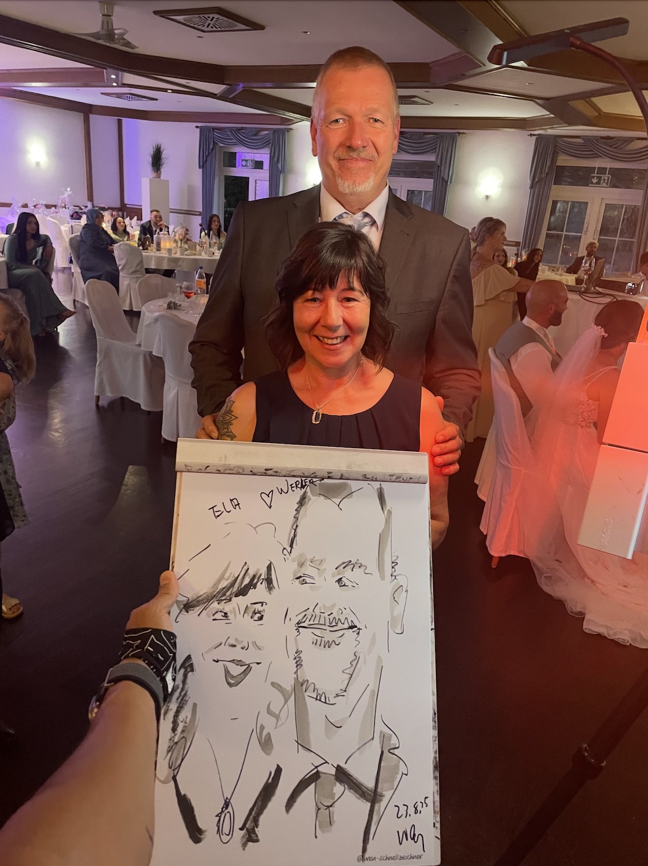 Bride and groom presenting their live drawn wedding portrait