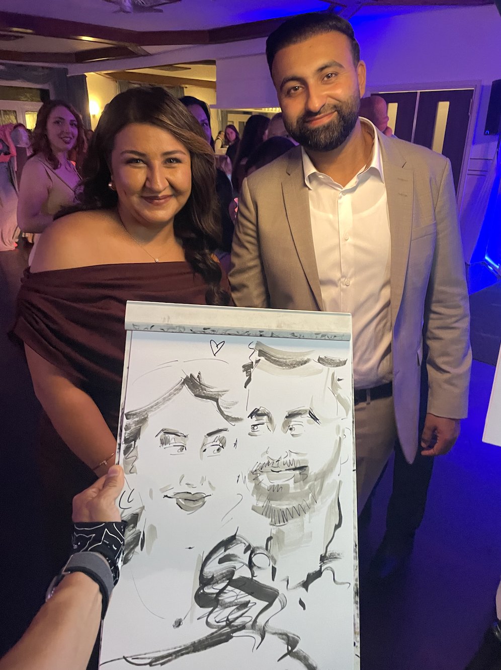 Wedding guests holding a live caricature at a celebration in Germany