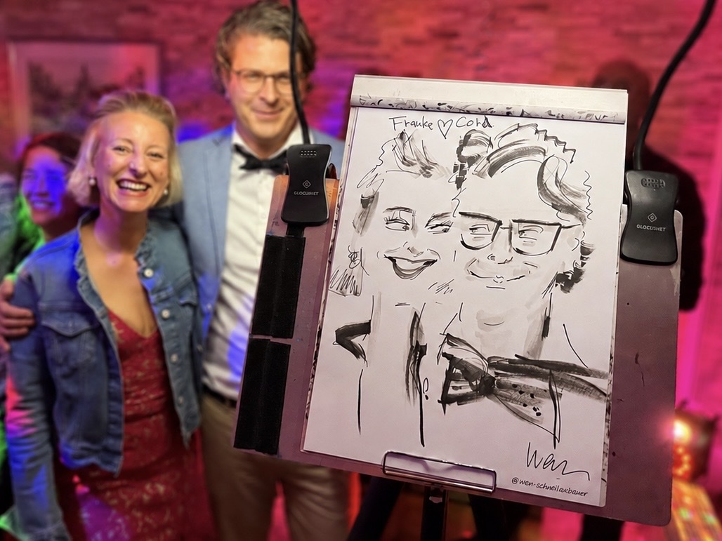 Couple with their live-drawn caricature at an event