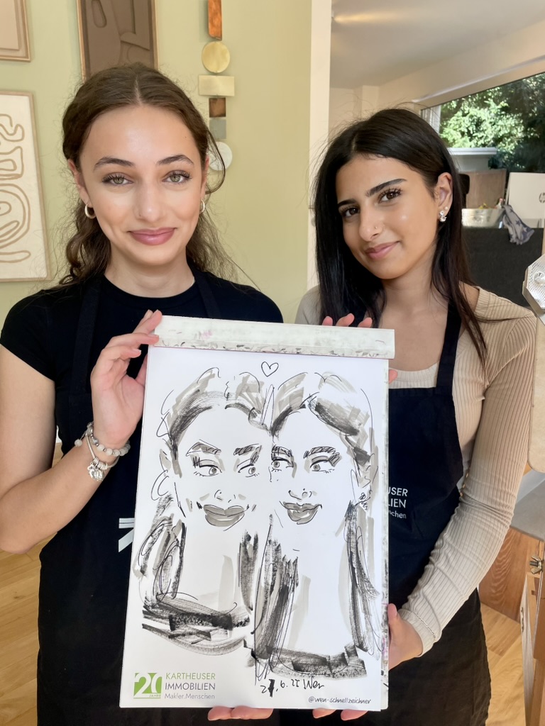 Two women with their shared live-drawn caricature